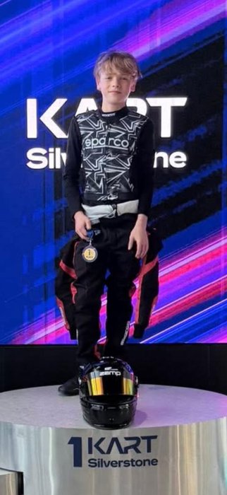 Driver holding a medal on the top step at Kart Silverstone